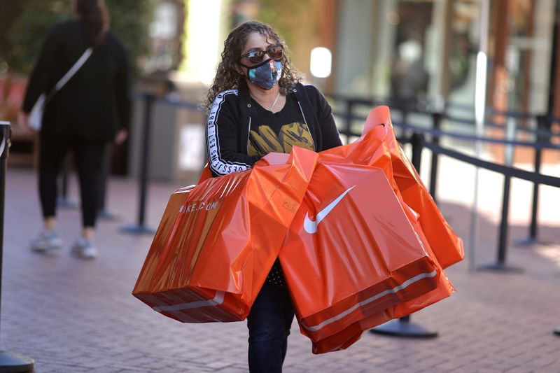 &copy; Reuters. FILE PHOTO: A woman carries Nike shopping bags at the Citadel Outlet mall, as the global outbreak of the coronavirus disease (COVID-19) continues, in Commerce, California, U.S., December 3, 2020. REUTERS/Lucy Nicholson/File Photo/File Photo