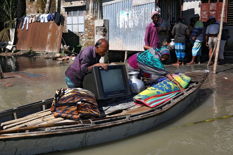 &copy; Reuters. FILE PHOTO: A family moves to a safe place with their belongings after the flood situation worsened in Munshiganj district, on the outskirts of Dhaka, Bangladesh, July 25, 2020. REUTERS/Mohammad Ponir Hossain/File Photo
