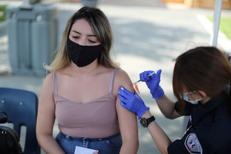 © Reuters. FILE PHOTO: Julissa Vasquez, 23, receives a coronavirus disease (COVID-19) vaccination as part of a vaccine drive by the Fernandeno Tataviam Band of Mission Indians in Arleta, Los Angeles, California, U.S., August 23, 2021. REUTERS/Lucy Nicholson/File Photo