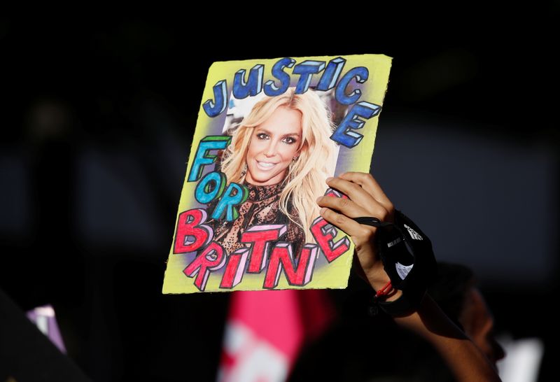 &copy; Reuters. Una fan de Britney Spears sostiene una foto de la artista pop durante las celebraciones del fin de la tutela sobre ella, fuera del tribunal de Stanley Mosk en Los Angeles, California, EEUU, 12 de noviembre de 2021. REUTERS/Mike Blake