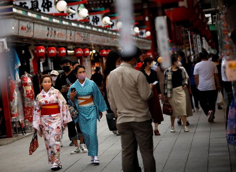 &copy; Reuters. FILE PHOTO: Kimono-clad tourists wearing protective face masks walk along Nakamise Street at Asakusa district, a popular sightseeing spot, amid the coronavirus disease (COVID-19) outbreak in Tokyo, Japan October 13, 2020.   REUTERS/Issei Kato