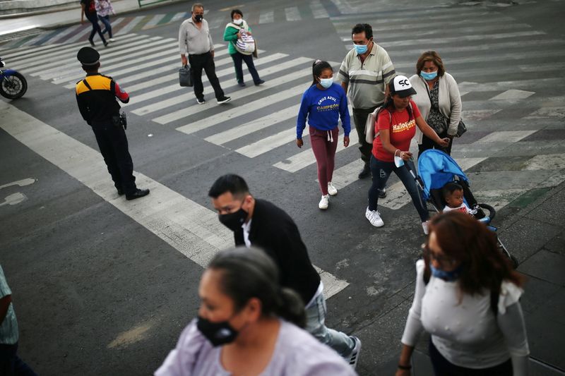 &copy; Reuters. أشخاص يضعون كمامات يعبرون أحد شوارع مكسيكو سيتي في الرابع من يونيو حزيران 2021. تصوير: إدجارد جاريدو - رويترز