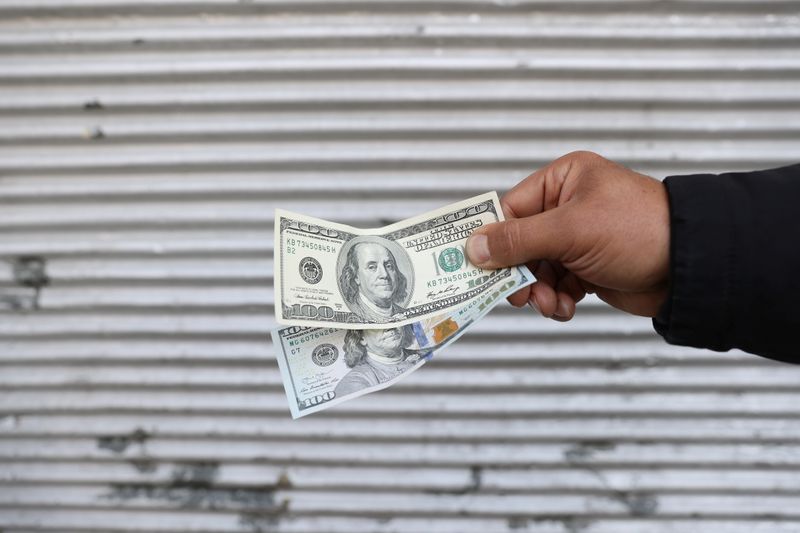 &copy; Reuters. A street-side currency vendor holds U.S. dollars at Ferdowsi Square in Tehran, Iran November 14, 2021. Majid Asgaripour/WANA (West Asia News Agency) via REUTERS ATTENTION EDITORS - THIS IMAGE HAS BEEN SUPPLIED BY A THIRD PARTY.