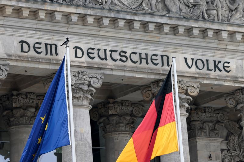 &copy; Reuters. Una bandiera tedesca e una bandiera Ue davanti al Reichstag a Berlino. REUTERS/Hannibal Hanschke