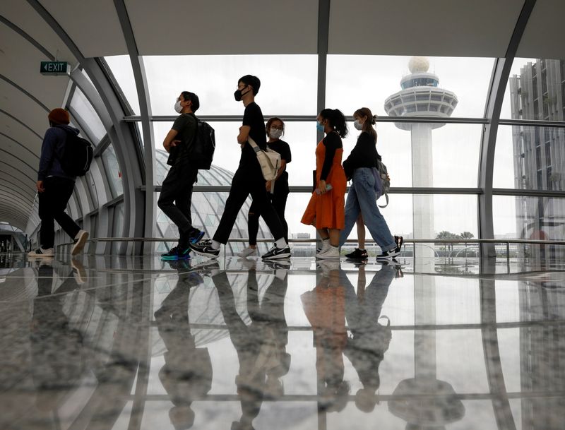 &copy; Reuters. أناس يمرون من أمام برج المراقبة في مطار شانجي الدولي في سنغافورة يوم 18 يناير كانون الثاني 2021. تصوير: إدجار سو - رويترز.