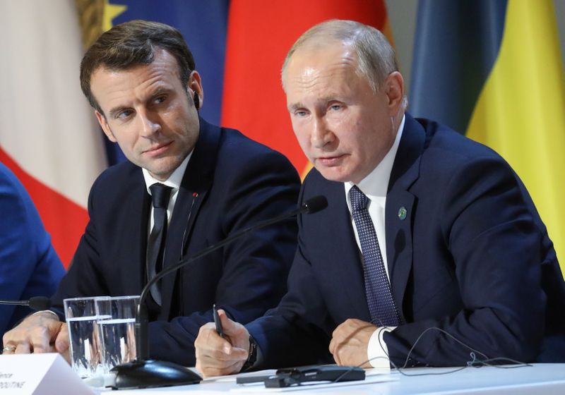 &copy; Reuters. フランスのマクロン大統領（右）はロシアのプーチン大統領（左）と電話会談を行い、ベラルーシ西部のポーランドなどとの国境に多数の移民が押し寄せている問題で、緊張緩和が必要との