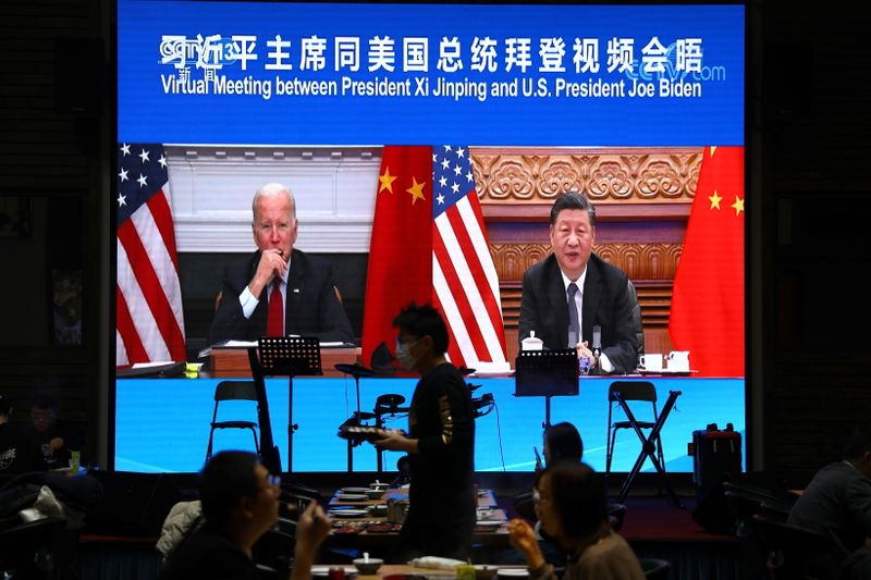 &copy; Reuters. شاشة في مطعم في بكين تعرض اجتماعا افتراضيا بين الرئيسين الأمريكي جو بايدن والصيني شي جين بينغ عبر رابط فيديو يوم الثلاثاء. تصوير: تينجشو وان