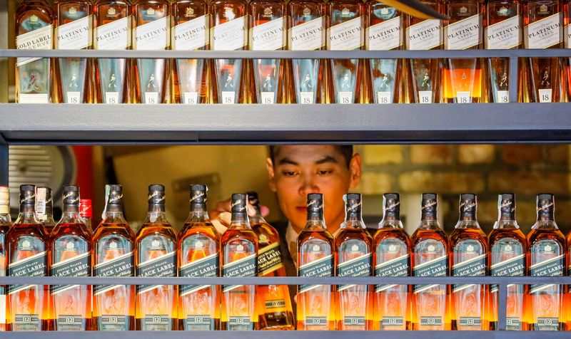 &copy; Reuters. Un barista prende una bottiglia di whisky Johnnie Walker ad Almaty Kazakhistan, 22 giugno 2017   REUTERS/Shamil Zhumatov/File Photo