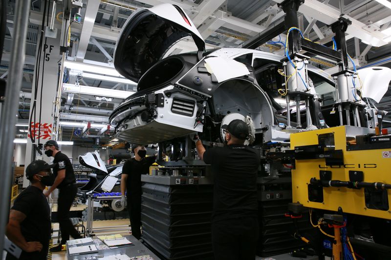 &copy; Reuters. FILE PHOTO: Workers marry the body structure with the battery pack and the front and rear sub frames as they assemble electric vehicles at the Lucid Motors plant in Casa Grande, Arizona, U.S. September 28, 2021.  REUTERS/Caitlin O'Hara