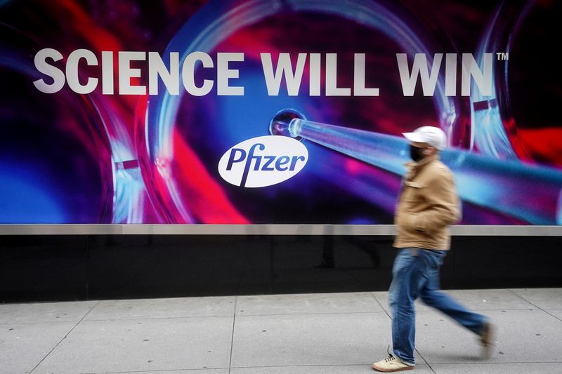 &copy; Reuters. FILE PHOTO: A person walks past the Pfizer Headquarters building in the Manhattan borough of New York City, New York, U.S., December 7, 2020. REUTERS/Carlo Allegri