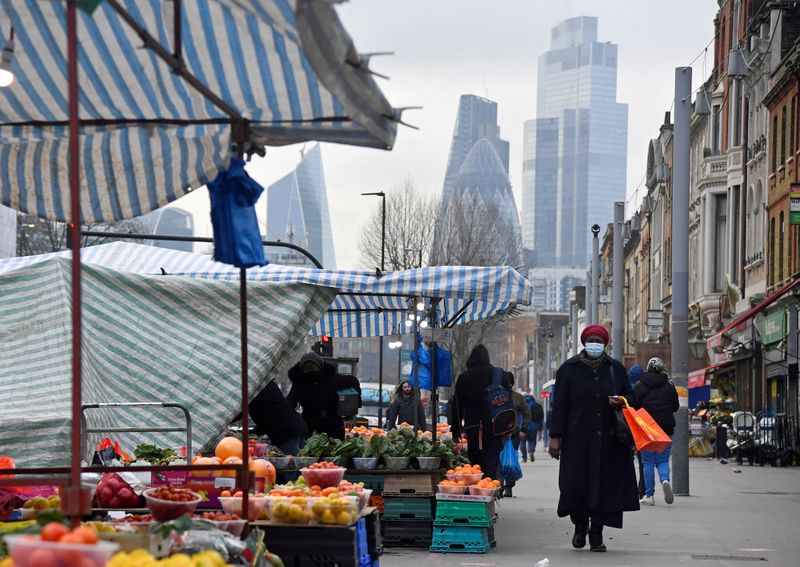 &copy; Reuters. FOTO DE ARCHIVO: La gente compra en los puestos del mercado, con los rascacielos del distrito financiero de CIty of London vistos detrás, en Londres