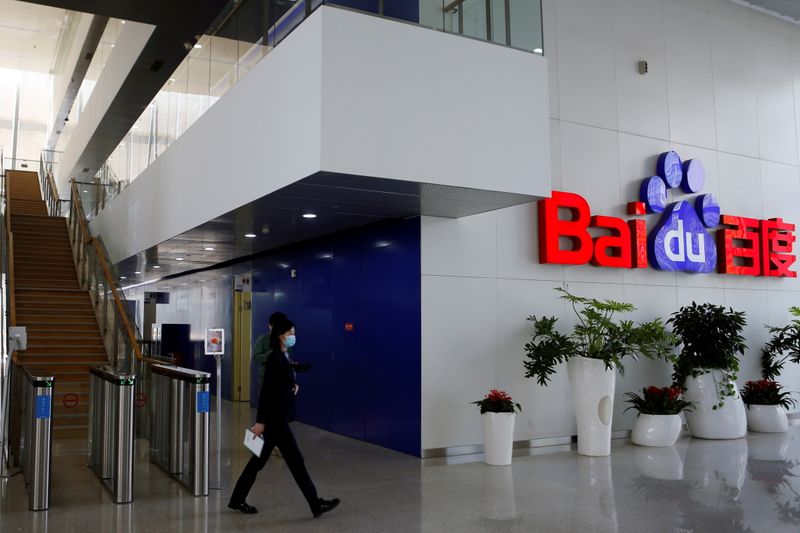 © Reuters. FILE PHOTO: People walk near a Baidu logo at the company headquarters in Beijing, China April 23, 2021. REUTERS/Florence Lo/File Photo