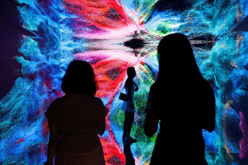 &copy; Reuters. FILE PHOTO: Visitors are pictured in front of an immersive art installation titled "Machine Hallucinations - Space: Metaverse" by media artist Refik Anadol, which will be converted into NFT and auctioned online at Sotheby's, at the Digital Art Fair, in Ho