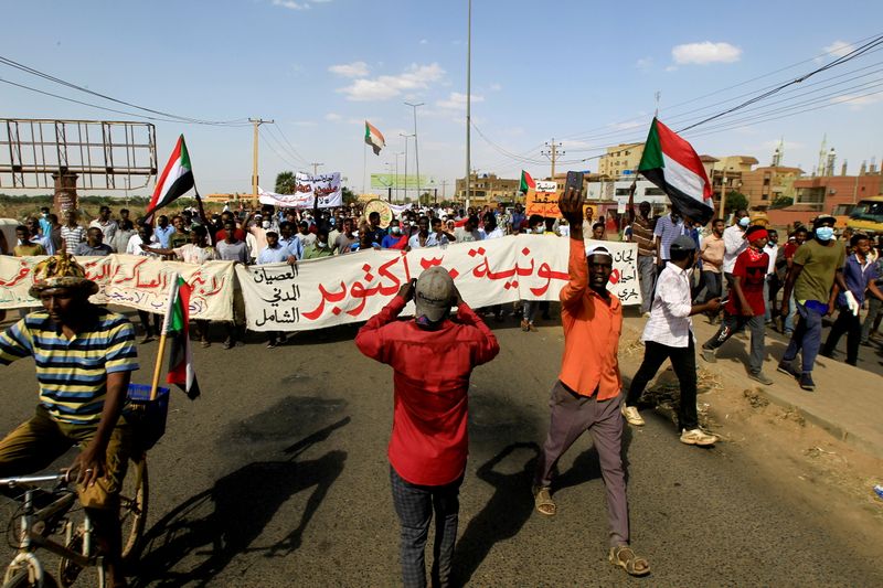 &copy; Reuters. FILE PHOTO: Protesters carry a banner and national flags as they march against the Sudanese military's recent seizure of power and ousting of the civilian government, in the streets of the capital Khartoum, Sudan October 30, 2021. REUTERS/Mohamed Nureldin