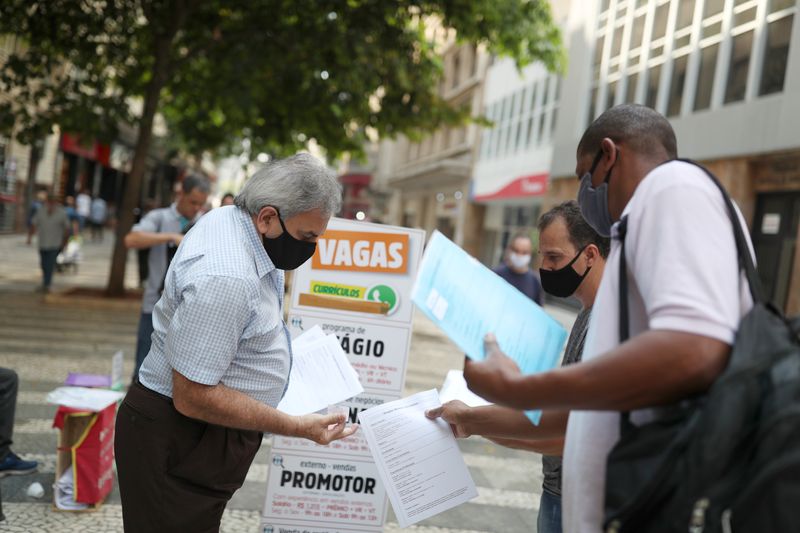 &copy; Reuters. FILE PHOTO: Men deliver resumes near a job listing on a board reading "Vacancies" in downtown Sao Paulo, Brazil, October 6, 2020. Picture taken October 6, 2020. REUTERS/Amanda Perobelli