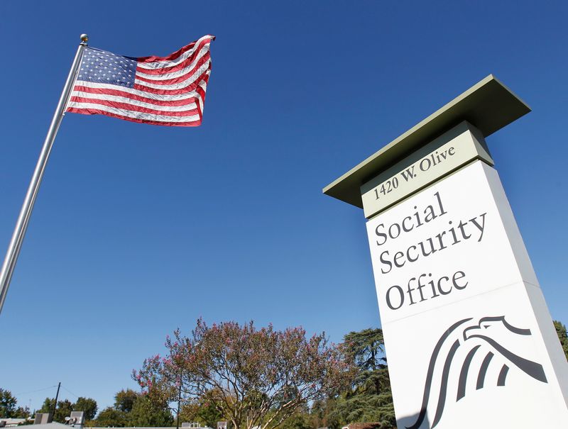 &copy; Reuters. FILE PHOTO: An American flag flutters in the wind next to signage for a United States Social Security Administration office in Burbank, California October 25, 2012. REUTERS/Fred Prouser/File Photo