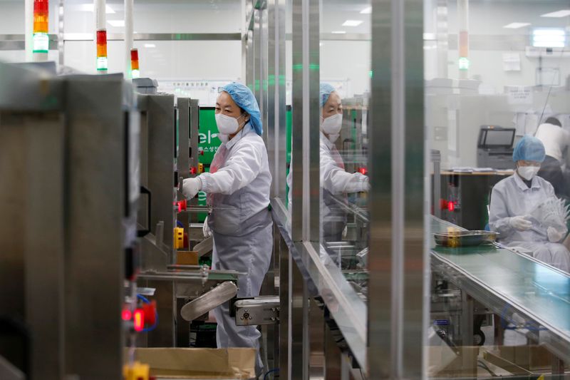 &copy; Reuters. FILE PHOTO: An employee works in an assembly line at a mask factory in Icheon, South Korea, March 6, 2020.  REUTERS/Heo Ran