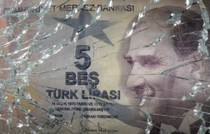 © Reuters. صورة توضيحية بتاريخ 25 أكتوبر تشرين الأول للوح زجاج مهشم أمام صورة لورقة نقد من الليرة التركية. رويترز.