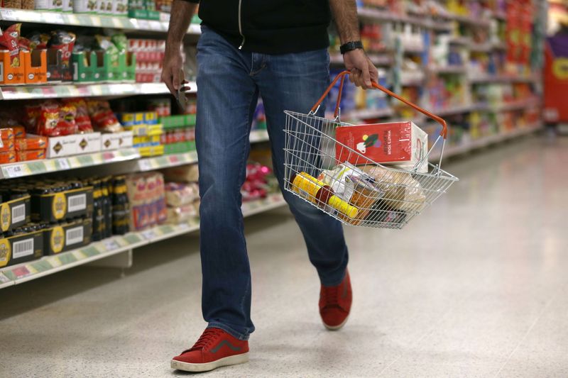 &copy; Reuters. FILE PHOTO: A shopper carries a basket in a supermarket in London, Britain April 11, 2017. REUTERS/Neil Hall/File Photo