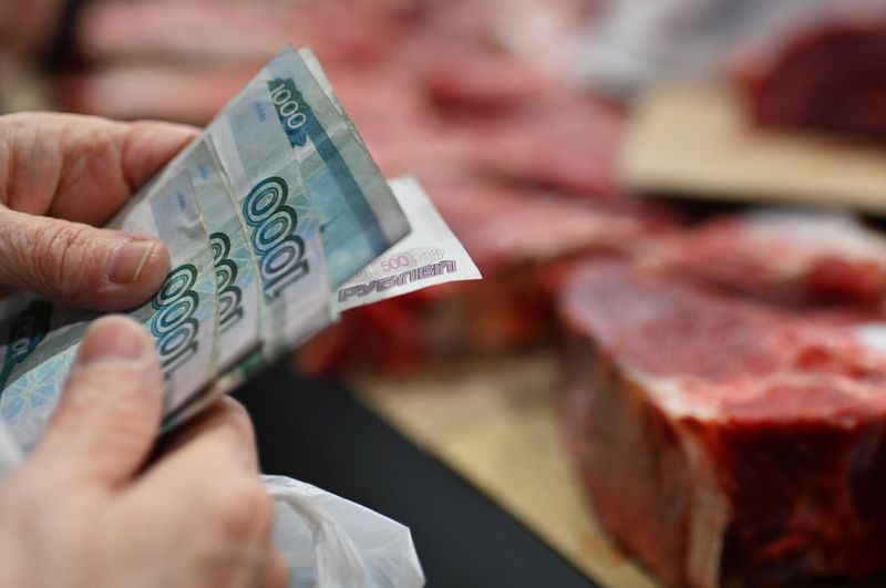 &copy; Reuters. A customer holds Russian rouble banknotes in a meat stall at a market in Omsk, Russia October 29, 2021. REUTERS/Alexey Malgavko