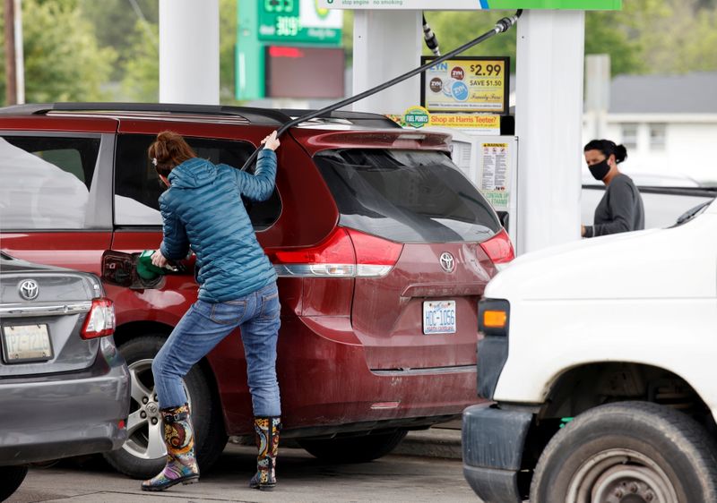 © Reuters. FILE PHOTO: A motorist stretches the fuel hose as far as it will go while filling up after a lengthy wait to enter a gasoline station during a surge in the demand for fuel following the cyberattack that crippled the Colonial Pipeline, in Durham, North Carolina, U.S. May 12, 2021.  REUTERS/Jonathan Drake/File Photo