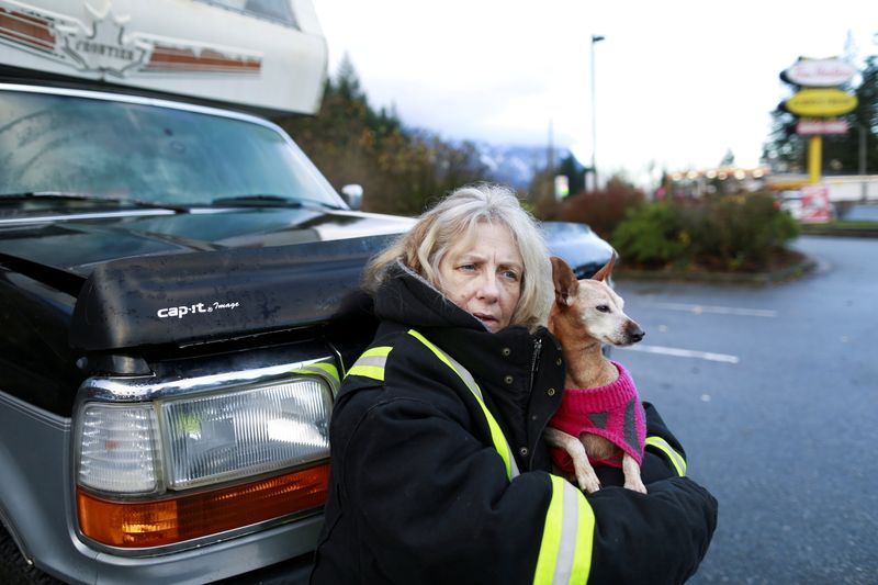 &copy; Reuters. Delia McLaren holds her dog Diamond in the parking lot of a Tim Hortons where she has been stranded for days after rainstorms caused flooding and landslides near Hope, British Columbia, Canada November 19, 2021. REUTERS/Jesse Winter