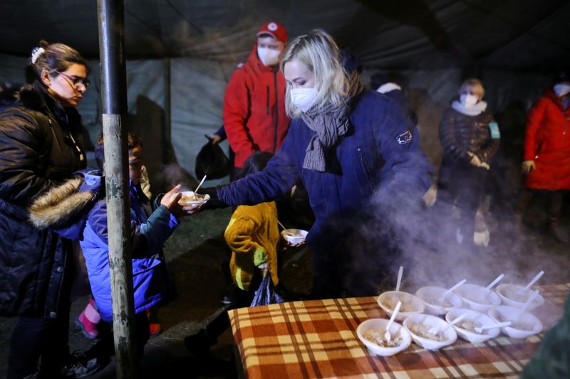 &copy; Reuters. مهاحرون يتلقون طعاما في مركز قرب الحدود بين روسيا البيضاء وبولندا يوم الأحد. تصوير كاسبر بمبل - رويترز.