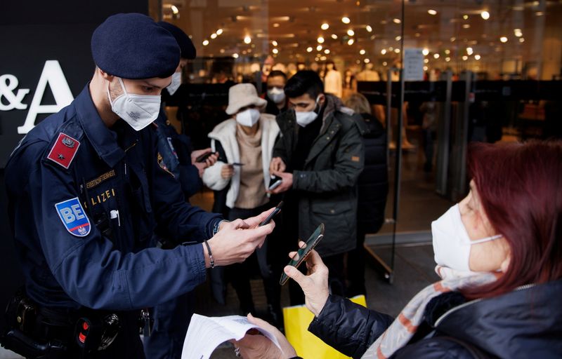 &copy; Reuters. FILE PHOTO: Police officers check the vaccination status of shoppers against the coronavirus disease (COVID-19) at the entrance of a store in Vienna, Austria, November 16, 2021. REUTERS/Lisi Niesner