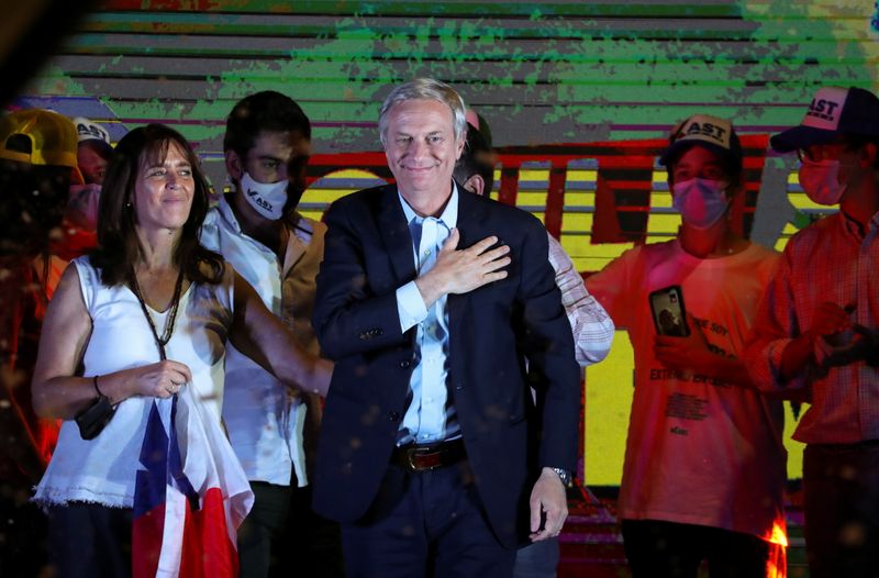 © Reuters. Chilean presidential candidate Jose Antonio Kast gestures as he stands next to his wife Maria Pia Adriasola Barroilhet after the partial results of the first round vote during the presidential elections, in Santiago, Chile, November 21, 2021. REUTERS/Ivan Alvarado