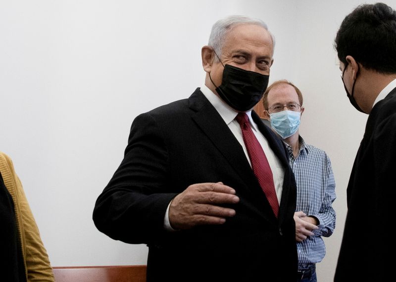 © Reuters. Former Israeli Prime Minister Benjamin Netanyahu is surrounded by journalists and lawyers in a courtroom before testimony by star witness Nir Hefetz, a former aide, in Netanyahu's corruption trial at the District Court in east Jerusalem, November 22, 2021. Maya Alleruzzo/Pool via REUTERS