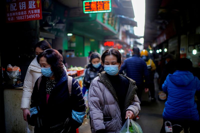 &copy; Reuters. FOTO DE ARCHIVO: Varias personas con mascarillas en un mercado callejero en Wuhan, provincia de Hubei, China, el 8 de febrero de 2021. REUTERS/Aly Song