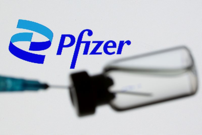 &copy; Reuters. Il logo Pfizer dietro a una fiala. REUTERS/Dado Ruvic