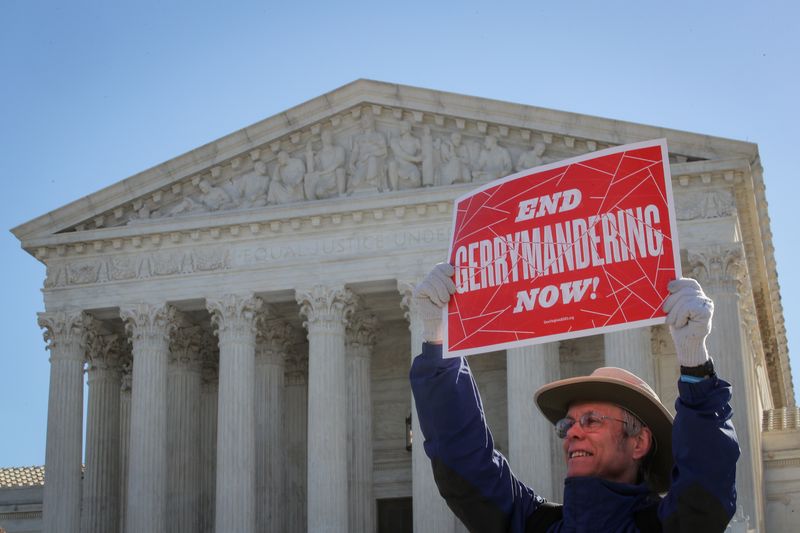 &copy; Reuters. FILE PHOTO: A demonstrator holds a sign during a Fair Maps rally outside the U.S. Supreme Court, in Washington, U.S., March 26, 2019.  REUTERS/Brendan McDermid/File Photo