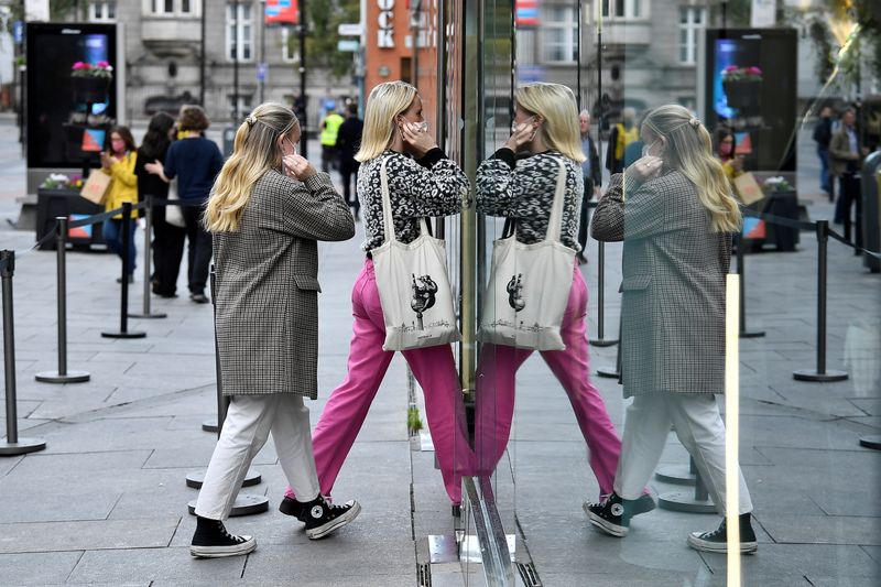 &copy; Reuters. FILE PHOTO: People are reflected in a window as they enter a shop in Dublin, Ireland, October 19, 2021. REUTERS/Clodagh Kilcoyne/File Photo