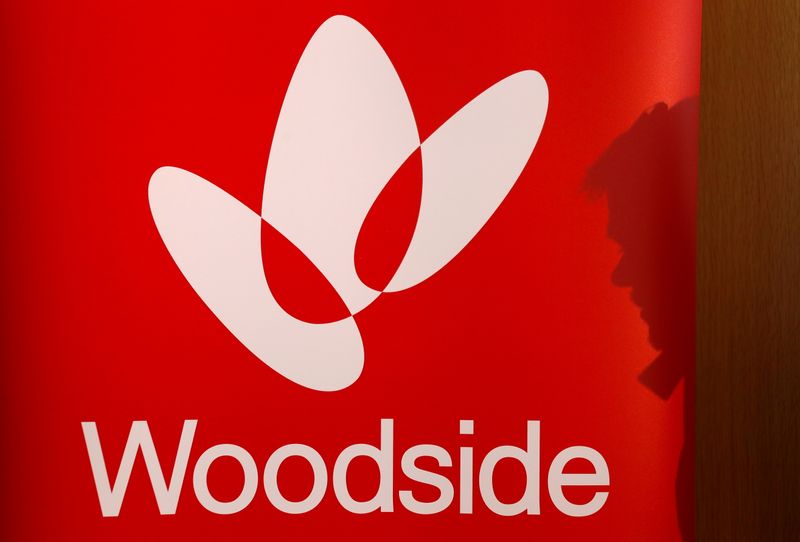 &copy; Reuters. FILE PHOTO: The shadow of a man is cast onto a poster displaying the logo for Australia's Woodside Petroleum at a briefing for investors in Sydney, Australia, May 23, 2018.  REUTERS/David Gray/File Photo