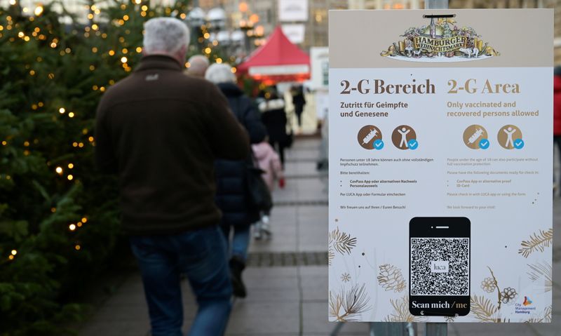 &copy; Reuters. Pessoas aguardam em frente a placa que sinaliza permissão para entrada somente de vacinados ou recuperados da Covid-19 em mercado de Natal em Hamburgo
22/11/2021 REUTERS/Fabian Bimmer