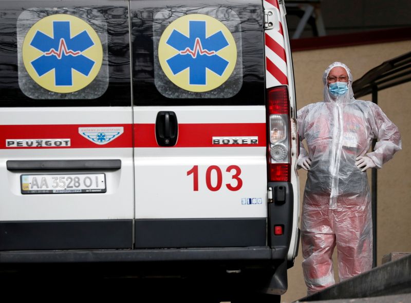 &copy; Reuters. FOTO DE ARCHIVO: Un trabajador sanitario junto a una ambulancia que transporta a un paciente con COVID-19, mientras esperan en la cola de un hospital para personas infectadas con la enfermedad del coronavirus en Kiev, Ucrania, 18 de octubre de 2021.  REUT