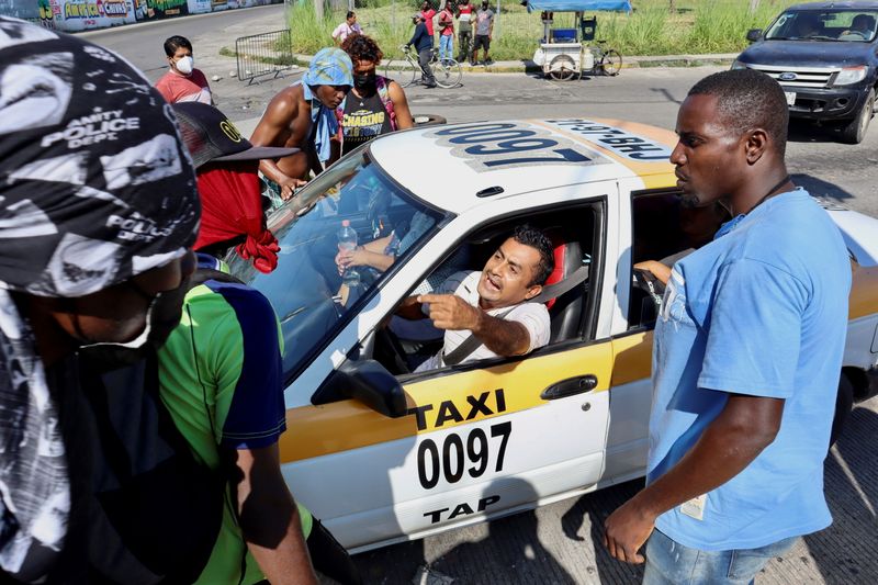 &copy; Reuters. A taxi driver yells to Haitian migrants blocking a street to protest after Mexican authorities cancelled the process to apply for humanitarian visas to be able to cross through Mexican territory to reach the U.S. border, in Tapachula, Mexico November 23, 