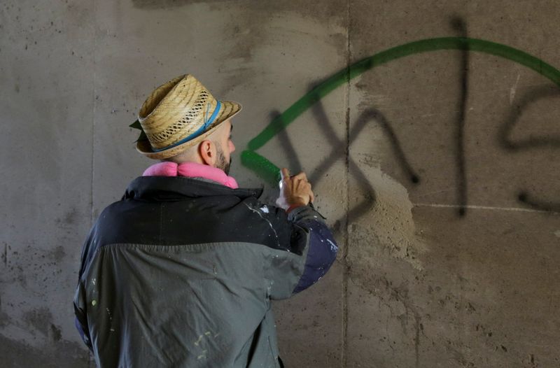 © Reuters. Foto del artista italiano Pier Paolo Spinazze pintando un graffitti sobre consignas nazis cerca de Verona
Nov 18, 2021. REUTERS/Chiara Negrello