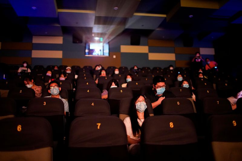 © Reuters. Imagen de archivo referencial de gente usando mascarillas mientras ve una película en el cine durante la reapertura de las salas en medio de la pandemia de COVID-19, en Shanghái, China. 20 de julio, 2020. REUTERS/Aly Song/Archivo
