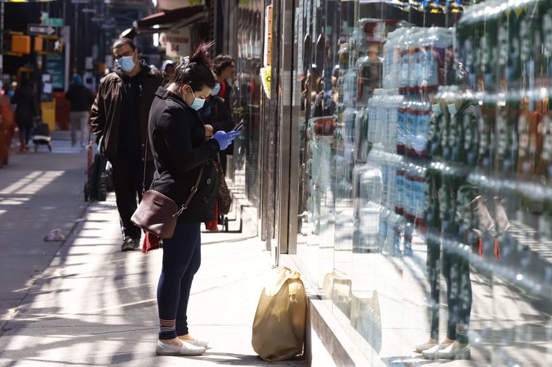 &copy; Reuters. Mulher envia mensagens de texto de seu telefone celular enquanto espera por um amigo do lado de fora de um supermercado na Roosevelt Avenue, no distrito do Queens, Nova York, EUA, 2 de abril de 2020. REUTERS/Stefan Jeremiah