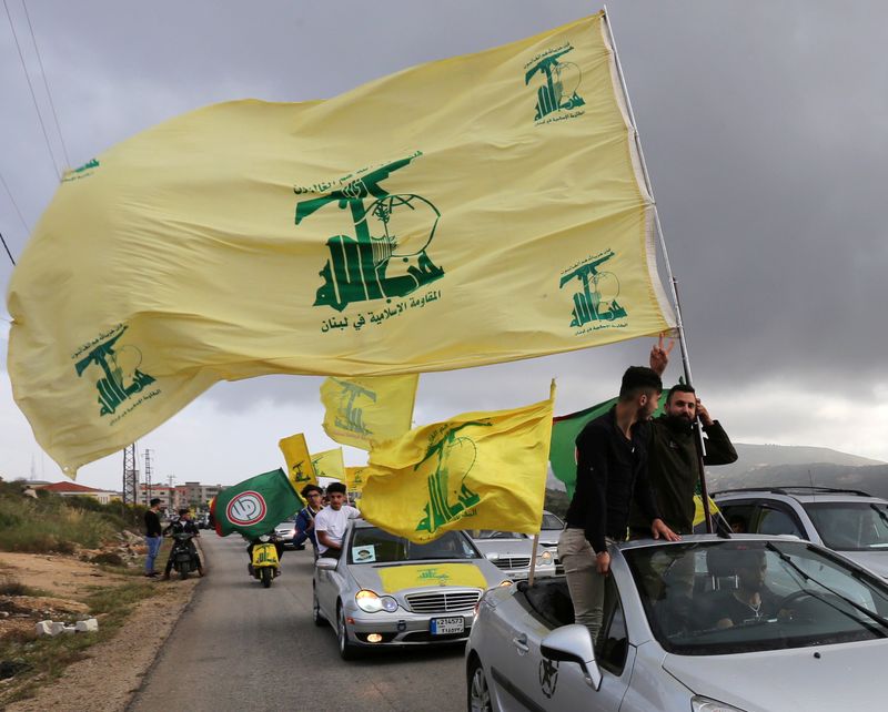 &copy; Reuters. مؤيدون لحزب الله اللبناني يرفعون علمه في موكب سيارات. رويترز