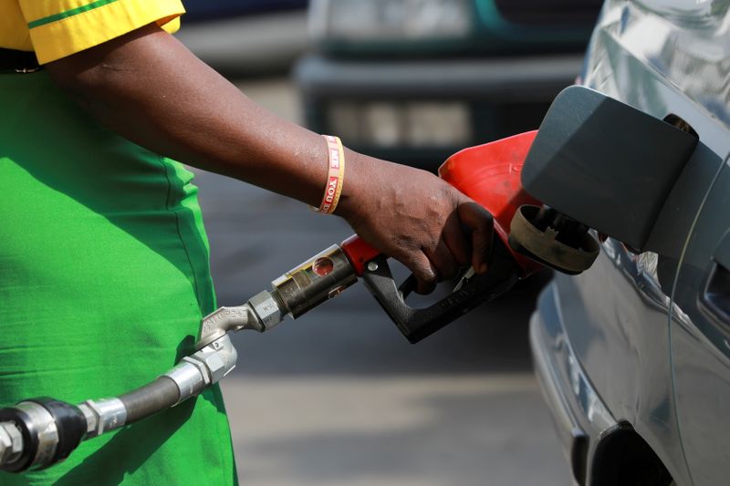 © Reuters. FILE PHOTO: A gas station attendant pumps fuel into a customer's car at the NNPC Mega petrol station in Abuja, Nigeria March 19, 2020. REUTERS/Afolabi Sotunde/File Photo
