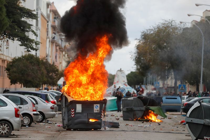 &copy; Reuters. El humo y las llamas se elevan desde un contenedor de basura incendiado durante una huelga de trabajadores del metal en Puerto Real, cerca de Cádiz, España, 24 de noviembre de 2021. REUTERS/Jon Nazca