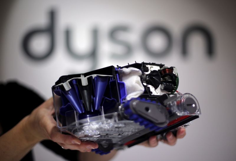 © Reuters. FILE PHOTO: A Dyson employee shows a Dyson 360 Eye robot vacuum cleaner without its cover during the IFA Electronics show in Berlin September 4, 2014. REUTERS/Hannibal Hanschke