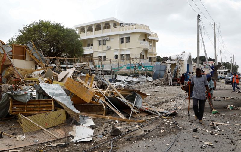 © Reuters. مدنيون يزيلون الحطام بعد انفجار سيارة في هجوم انتحاري قرب مدرسة في العاصمة الصومالية مقديشو يوم الخميس. تصوير فيصل عمر- رويترز.
