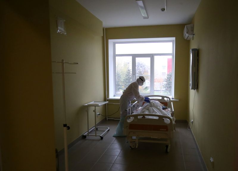 &copy; Reuters. FILE PHOTO: A medical specialist wearing protective gear tends to a patient at the City Clinical Hospital Number 1, where people suffering from the coronavirus disease (COVID-19) are treated, in Volzhsky, Russia October 25, 2021. REUTERS/Kirill Braga/File