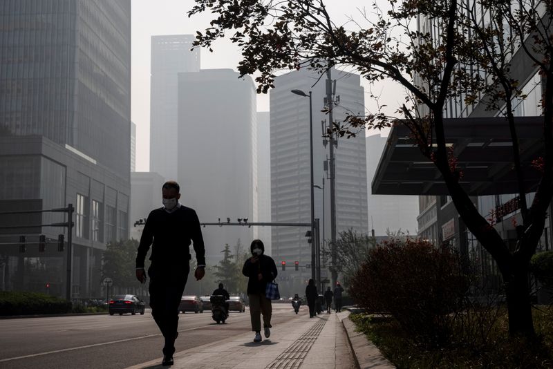 &copy; Reuters. FILE PHOTO: People walk in the Central Business District (CBD) on a hazy morning in Beijing, China, October 25, 2021.   REUTERS/Thomas Peter