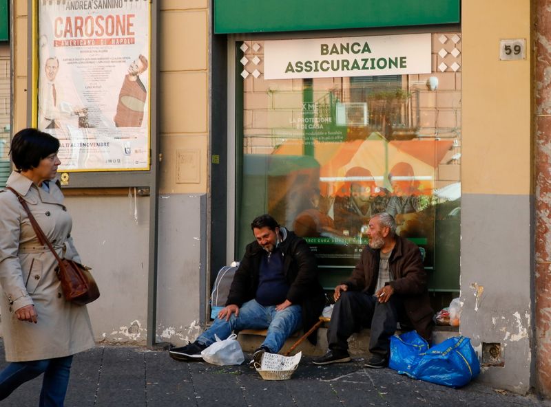 &copy; Reuters. Men beg on the street in Naples, Italy, November 20, 2021. REUTERS/Ciro De Luca
