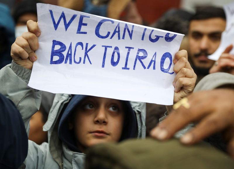 &copy; Reuters. طفل من المهاجرين يرفع لافتة كتب عليها "لا يمكننا العودة للعراق" خارج مركز نقل ولوجيستيان على الحدود بين روسيا البيضاء وبولندا يوم الخميس. تص